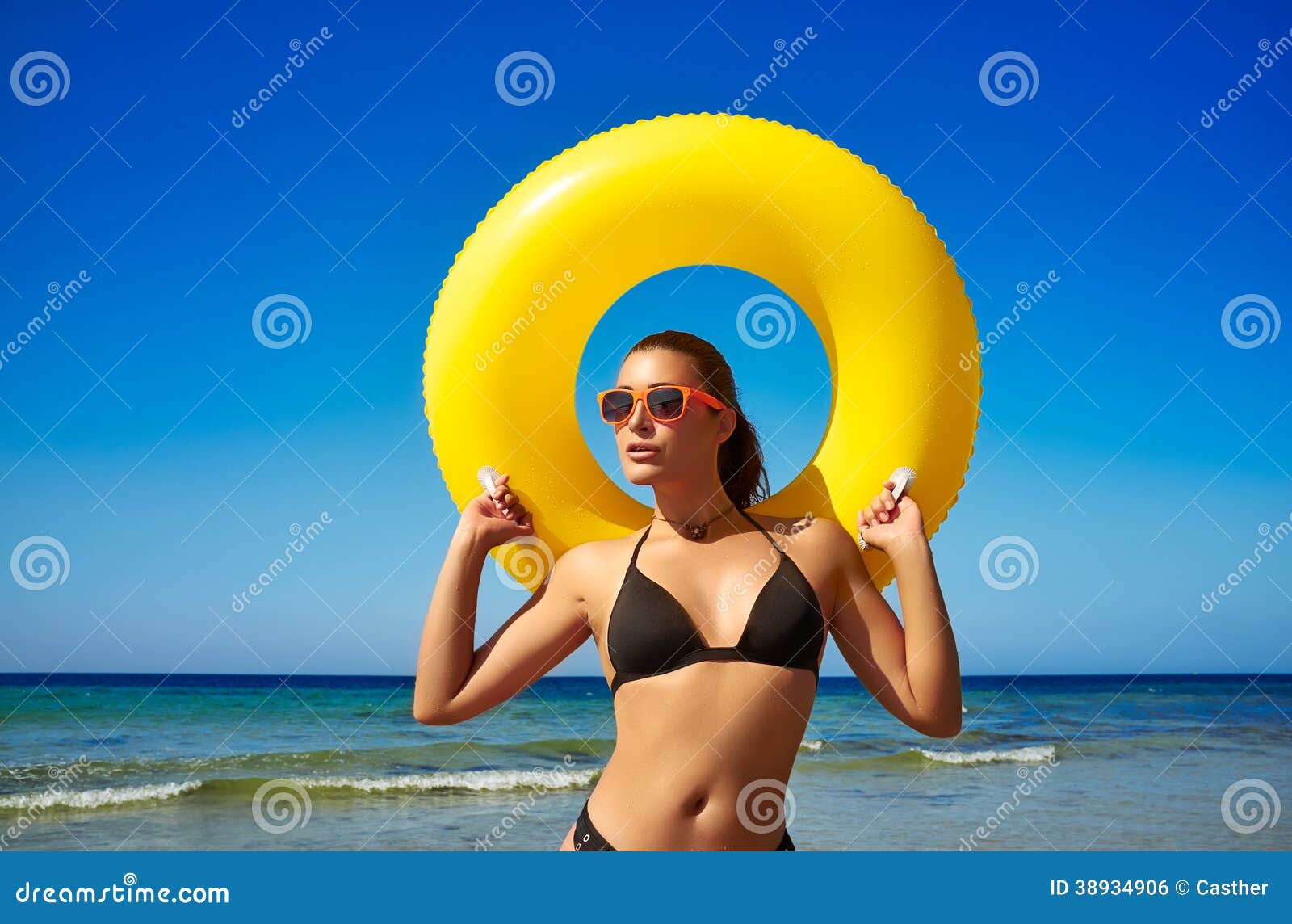 有巨型浮游物的美丽的海滩女孩在海滨。五颜六色的夏天。