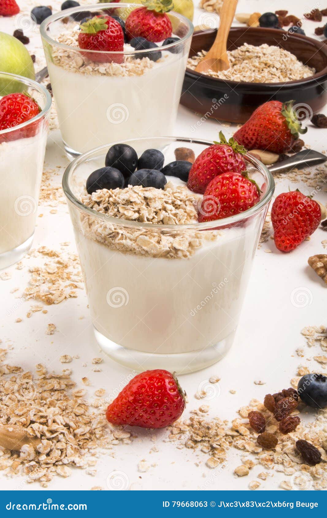 健康早餐用新鲜的冷的酸奶和果子. 健康早餐用新冷的酸奶、草莓、蓝莓和oatflakes在玻璃