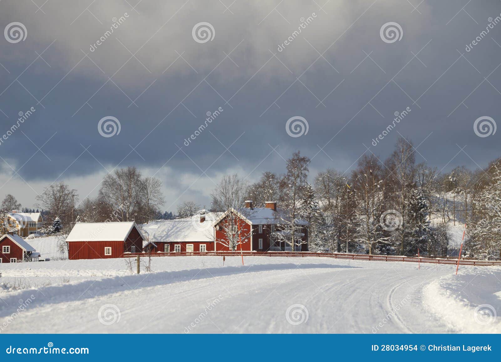 冬天横向的老农厂房子. 一处多雪的冬天风景的老红色农厂房子，在展望期的黑暗的云彩。 smaland。 瑞典