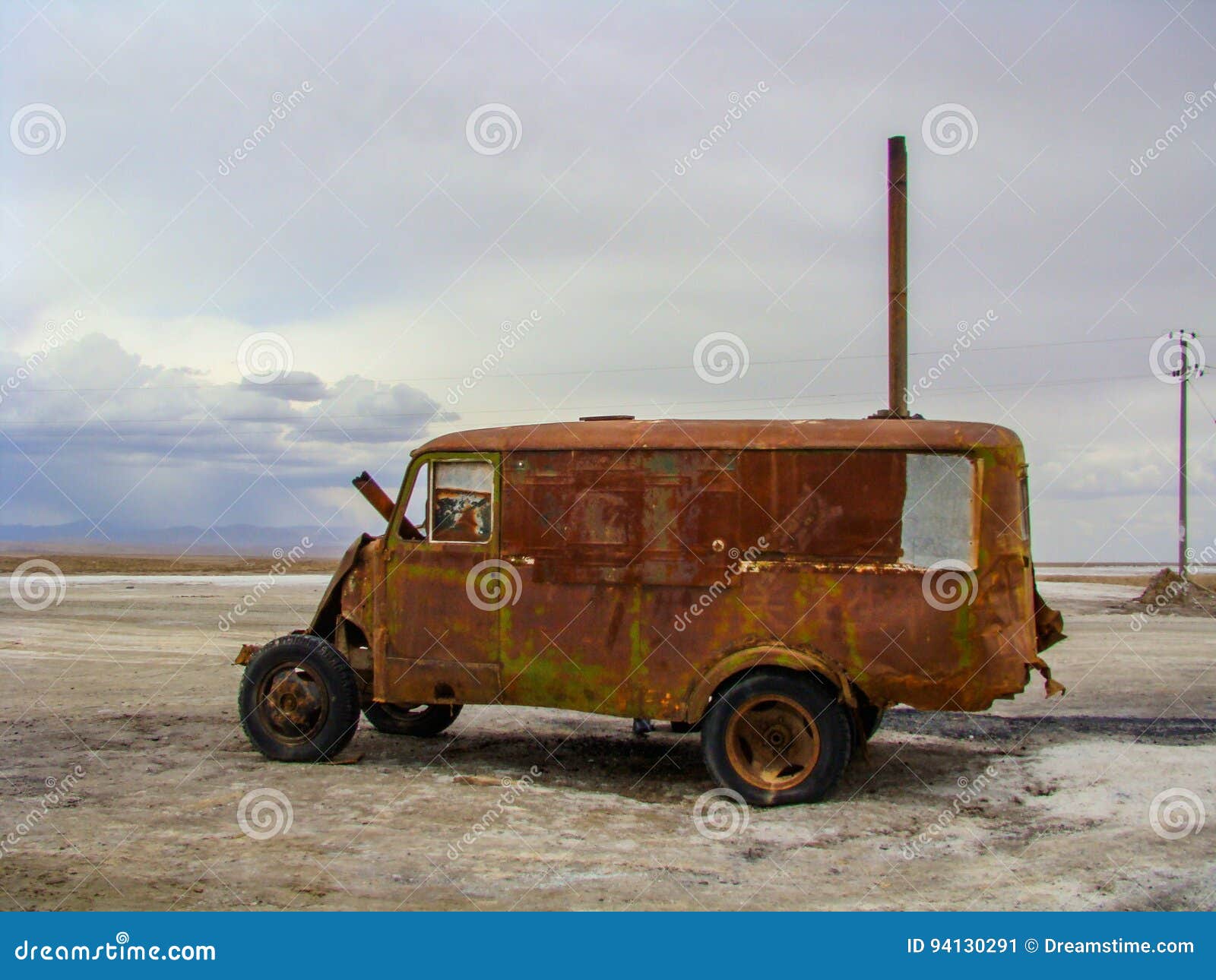 在地面上的老丰富的汽车. 有它生锈的金属的一辆老丰富的汽车在盐地面