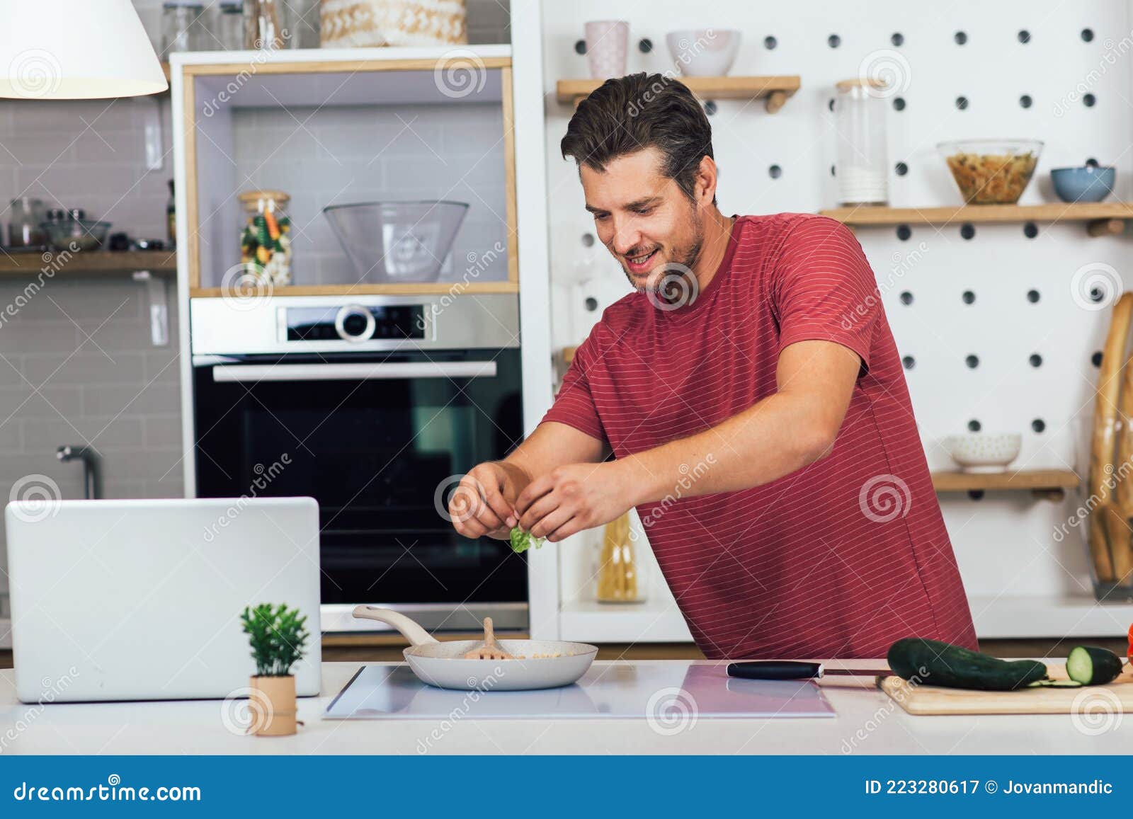 男人在锅里煮汤在黑暗的背景，在家里做饭照片摄影图片_ID:391483781-Veer图库