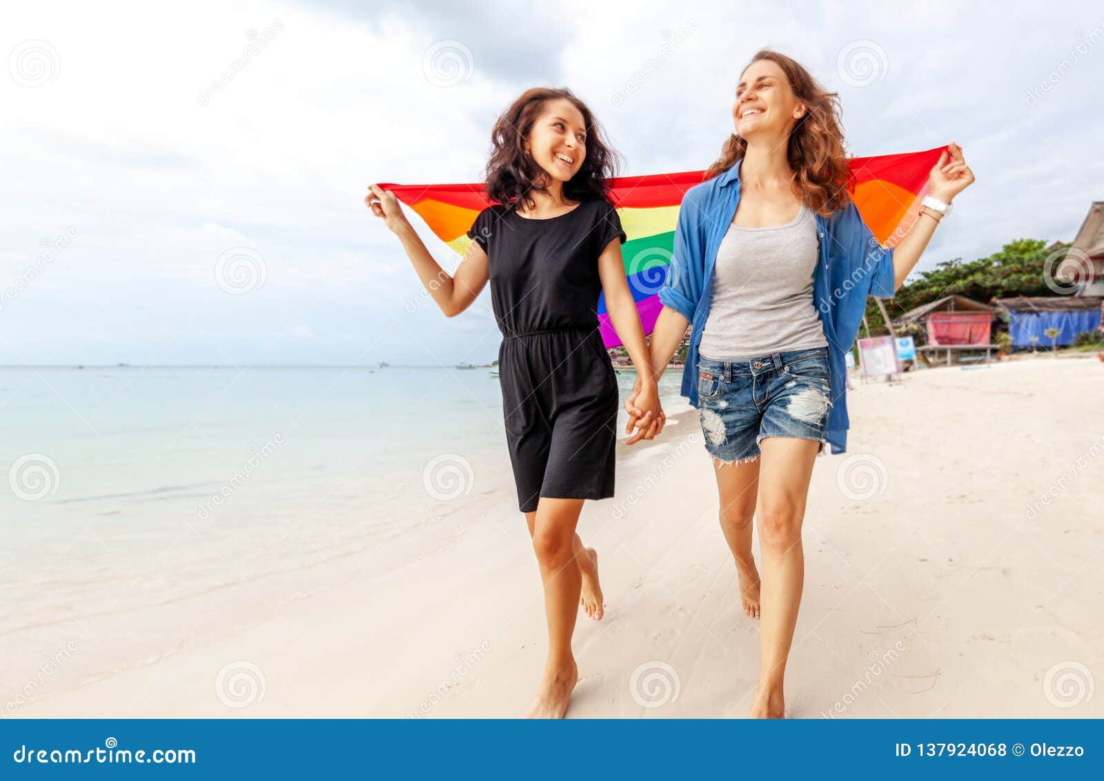 爱情白天一对年轻情侣沙滩拥抱转圈圈摄影图配图高清摄影大图-千库网