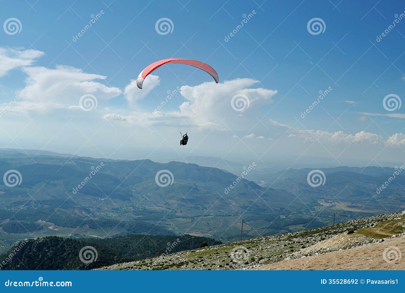 在飞行中滑翔伞. 飞行在山的滑翔伞在西班牙