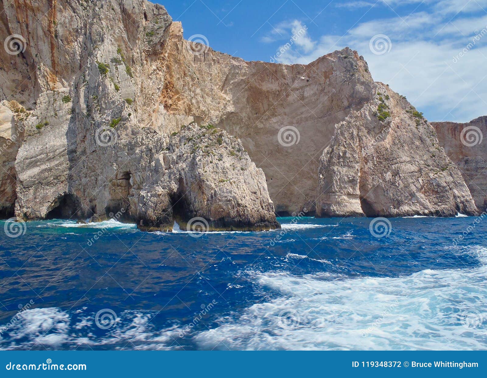 坚固性海岸线和洞，扎金索斯州希腊海岛，希腊. 与洞沿水线，扎金索斯州，一个爱奥尼亚人希腊海岛，希腊的坚固性海岸线峭壁，有干净的大海的
