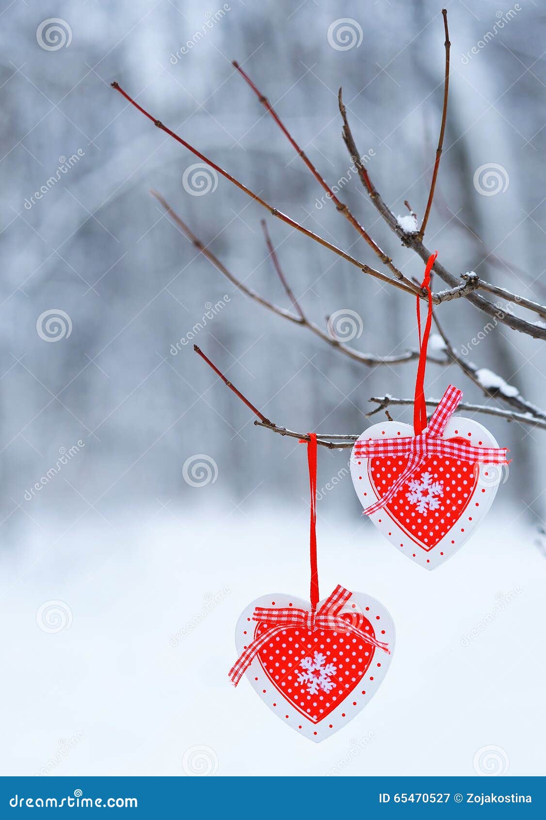 垂悬在thee分支的红色装饰心脏. 充分递在一棵树的红色心脏装饰细节在冬天森林里雪 冬天季节假日概念