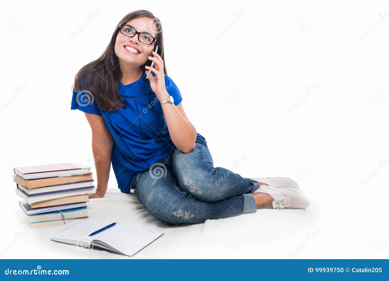 学生女孩坐的谈话在电话. 学生女孩做谈话在电话和微笑与被隔绝的书坐白色背景