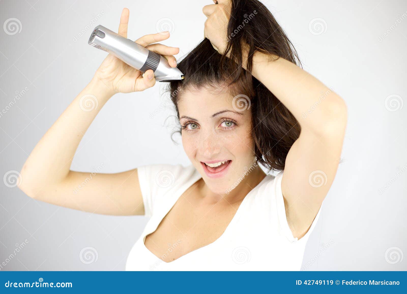 一位女士模特拿着吹风机吹着自己的头发美妆时尚素材设计