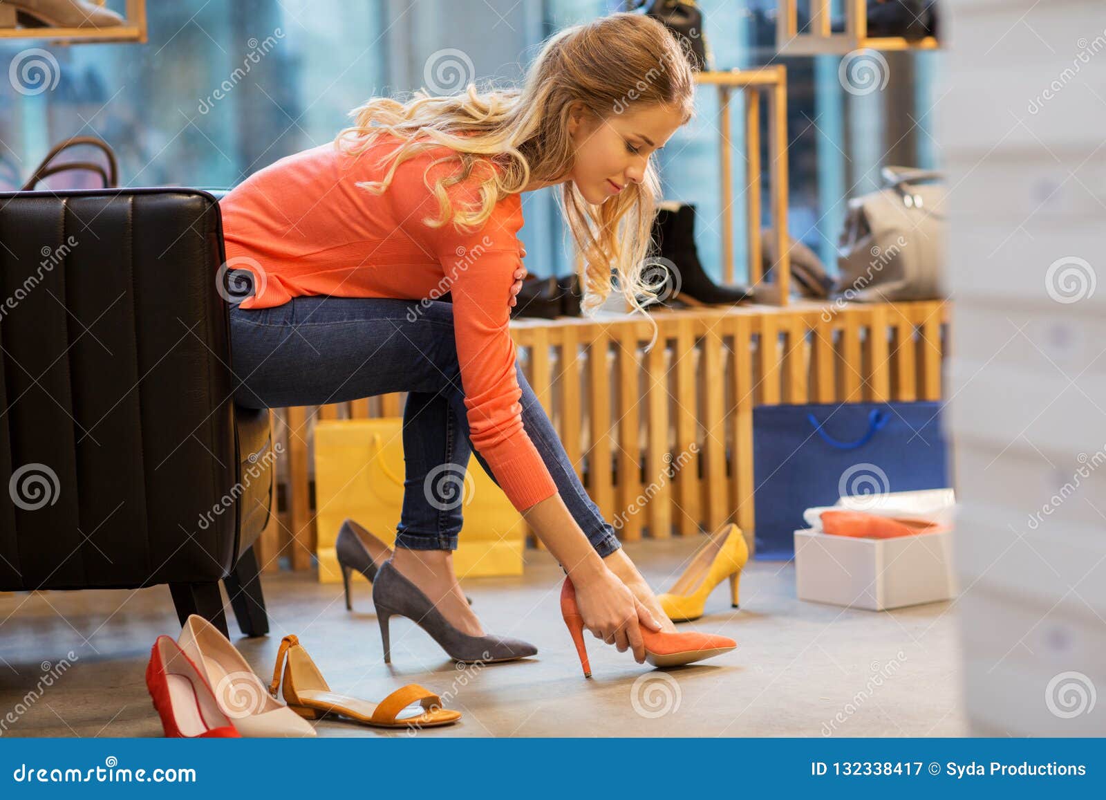 尝试高跟鞋的少妇在商店. 销售、购物、时尚和人概念-选择高跟鞋的少妇在商店