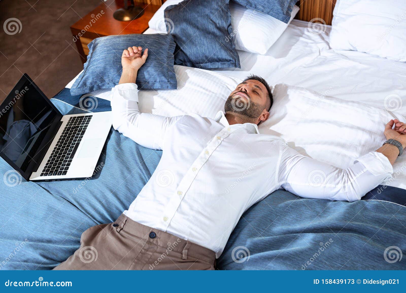 微笑的帅哥躺在床上使用平板电脑高清摄影大图-千库网