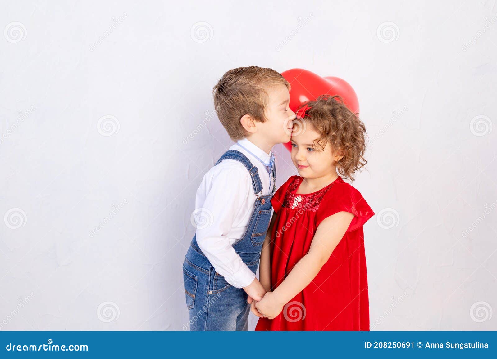 熊妹妹亲吻着哥哥的脸颊，在屋外温暖的拥抱着。他看起来很开心，微笑着。女孩对他的朋友男孩表示喜爱，亲吻他的脸颊照片摄影图片_ID ...