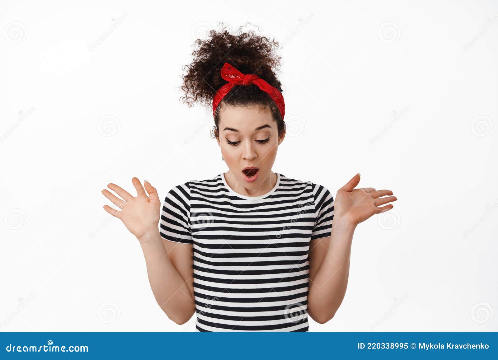 惊吓的黑发女孩举起双手,望向低处,望着低声,惊讶地发现库存 惊吓的黑发女孩举起双手,望向低处,望着低声,惊讶地发现库存