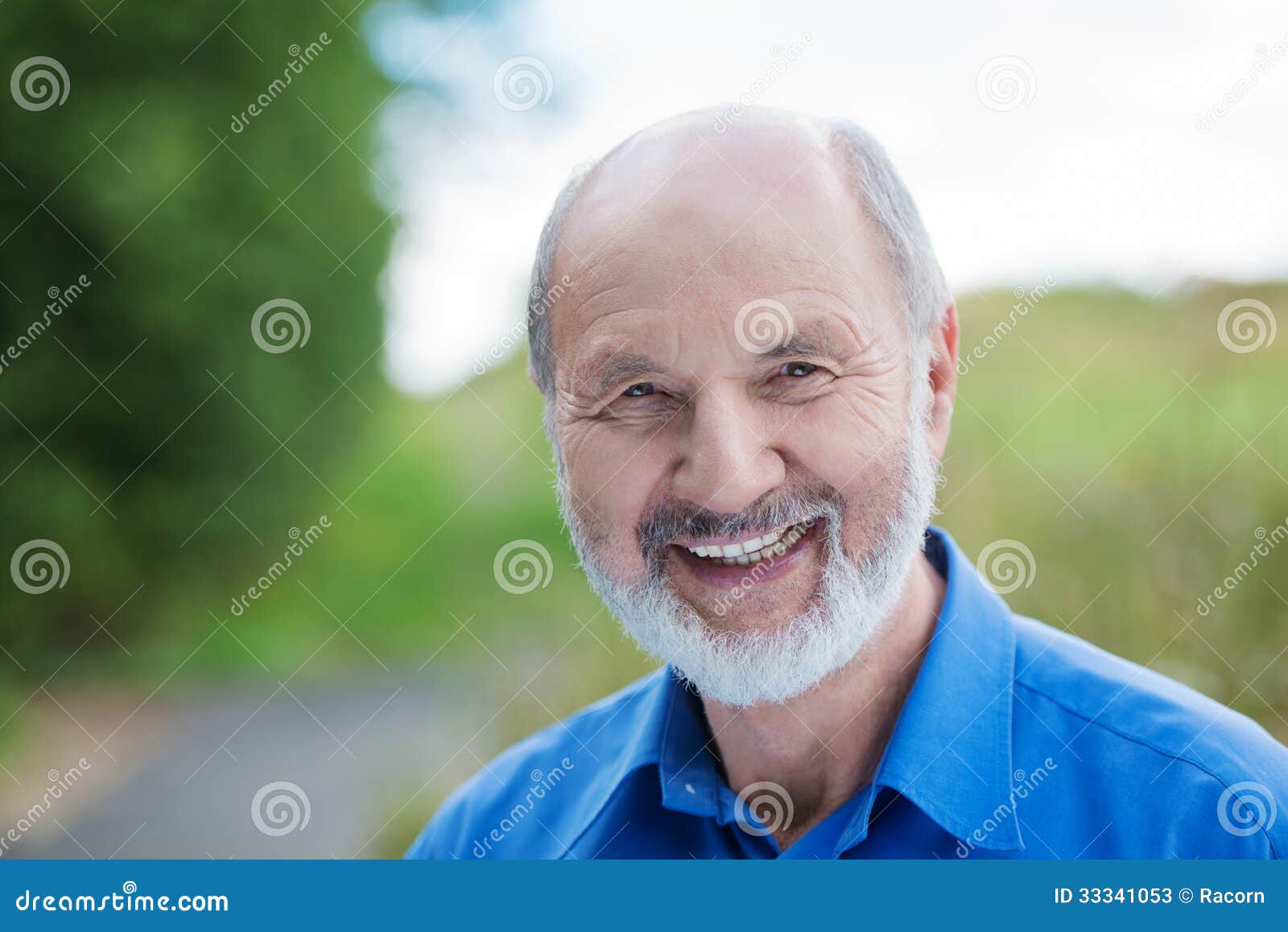愉快的白种人退休的有胡子的人，户外. 一个愉快的白种人的水平的画象在背景中退休了有胡子的人，户外有被弄脏的绿地的
