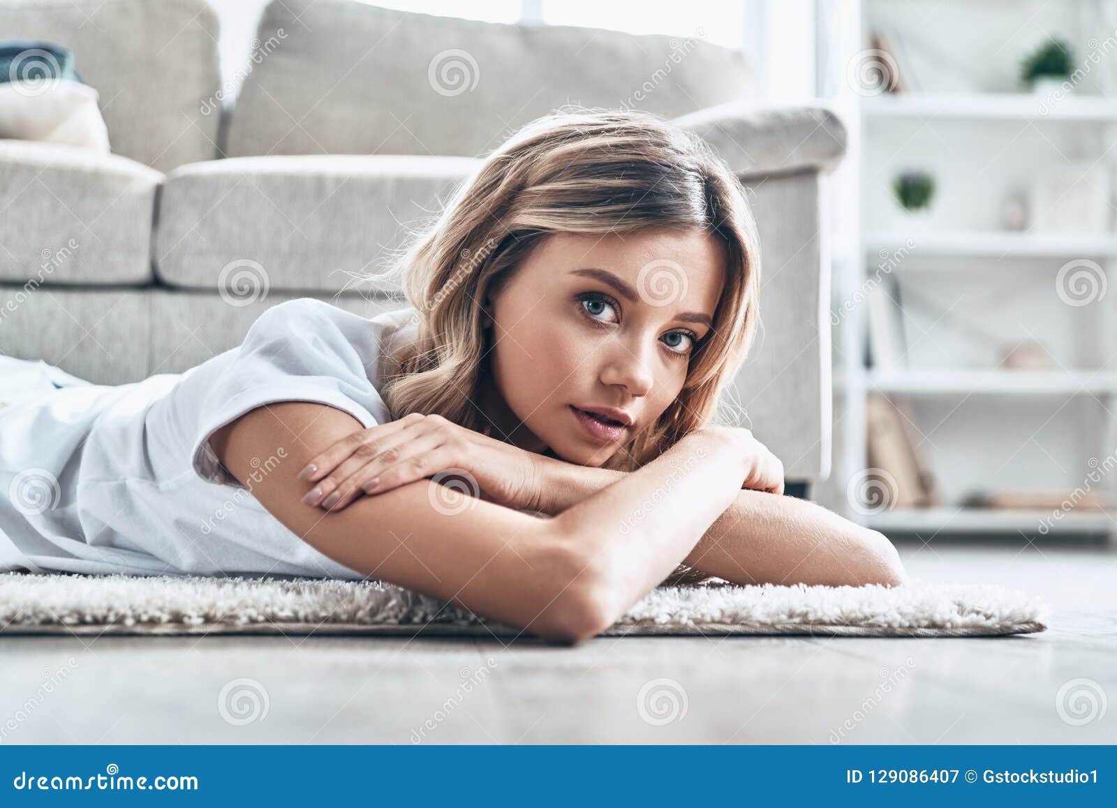 懒惰的红发女孩在床上。一个懒散的姜黄色女孩，早上躺在床上，用床单蒙住头，不想起床。照片摄影图片_ID:414520569-Veer图库