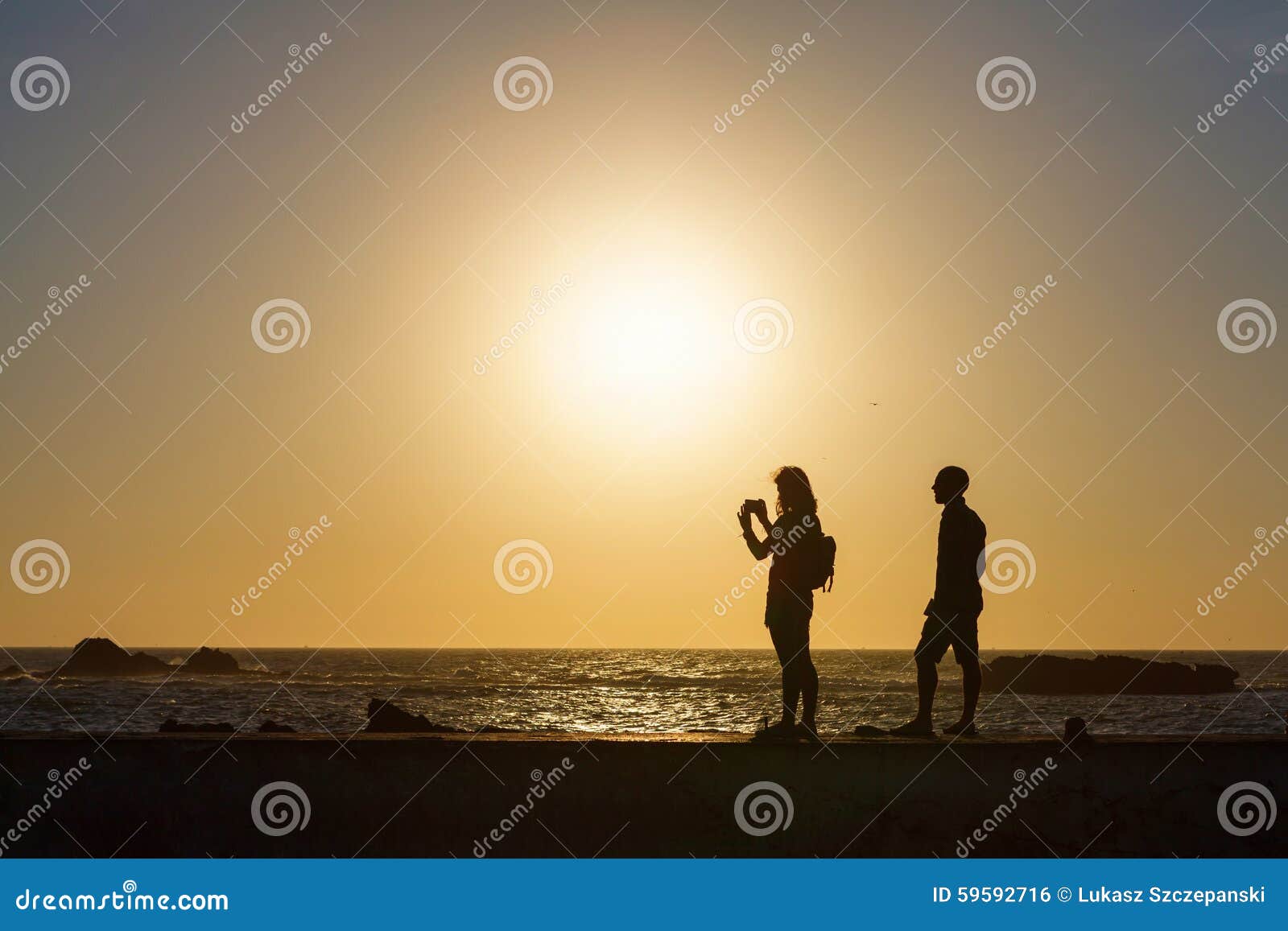 拍照片的夫妇剪影由海. 拍照片的夫妇剪影海索维拉，摩洛哥