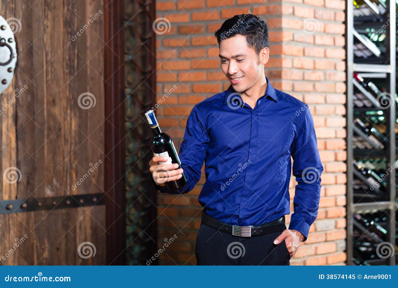 拿着瓶红葡萄酒的年轻斟酒服务员在地窖里 库存图片. 图片 包括有 成功, 男性, 酒客, 酿酒厂, 葡萄酒 - 88261665