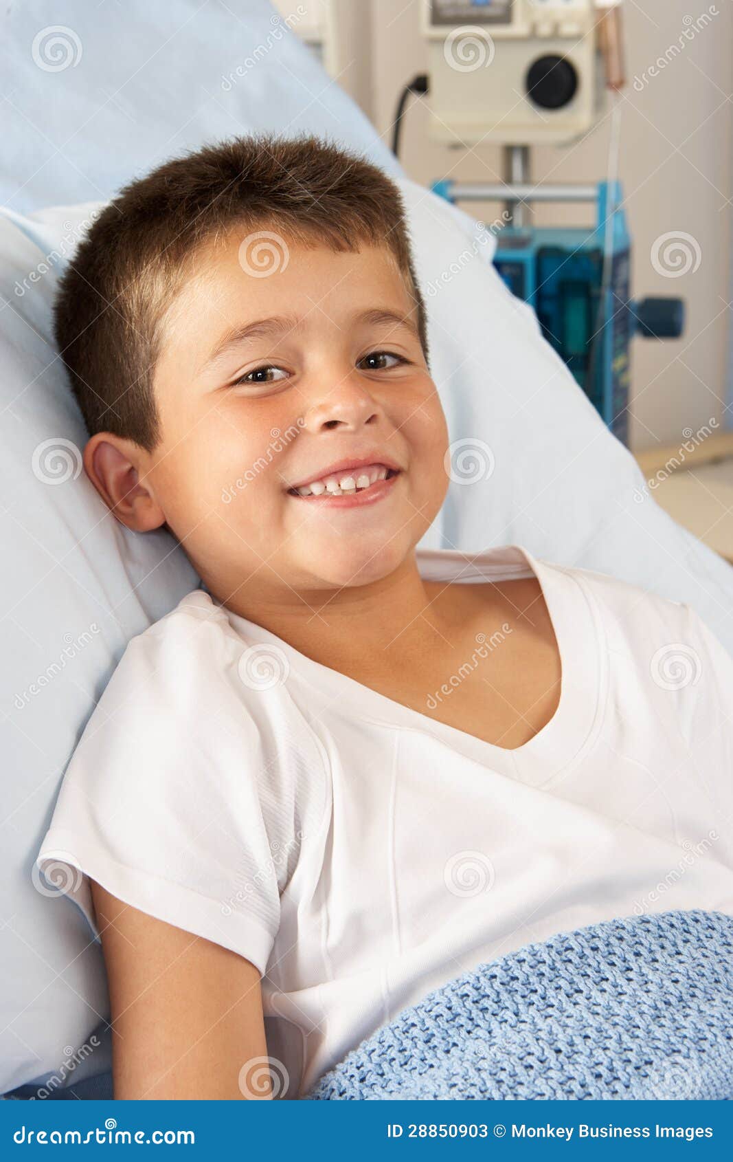 放松在医院病床上的男孩. 放松在医院病床微笑的男孩