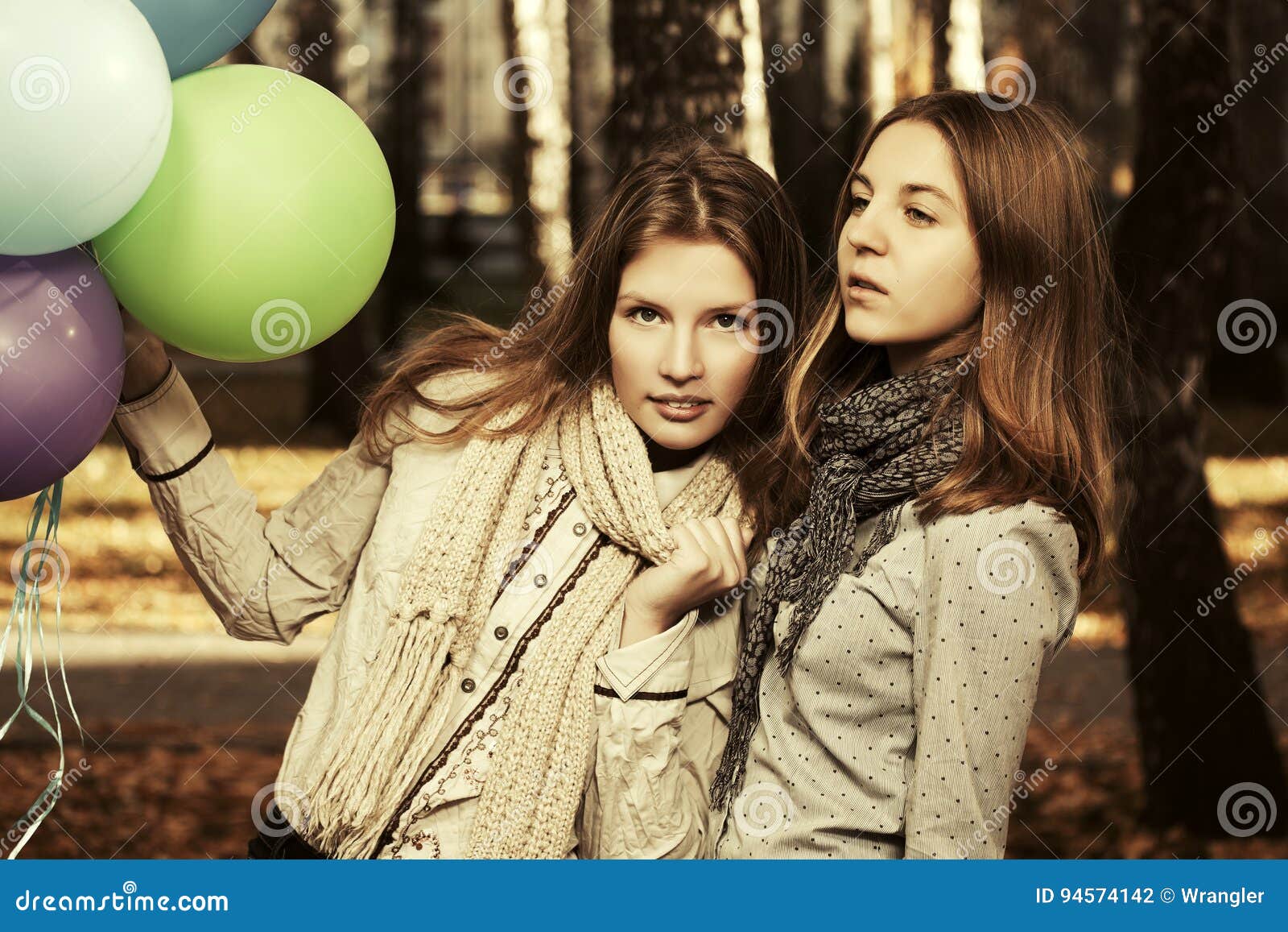 有的两个时尚青少年的女孩气球走在秋天的停放