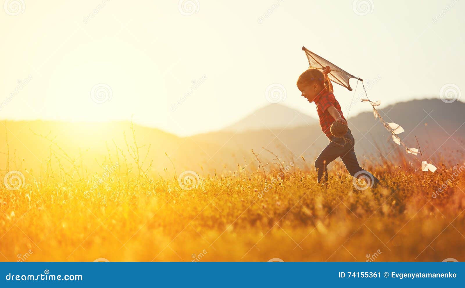 有跑在草甸的风筝的愉快的儿童女孩在夏天