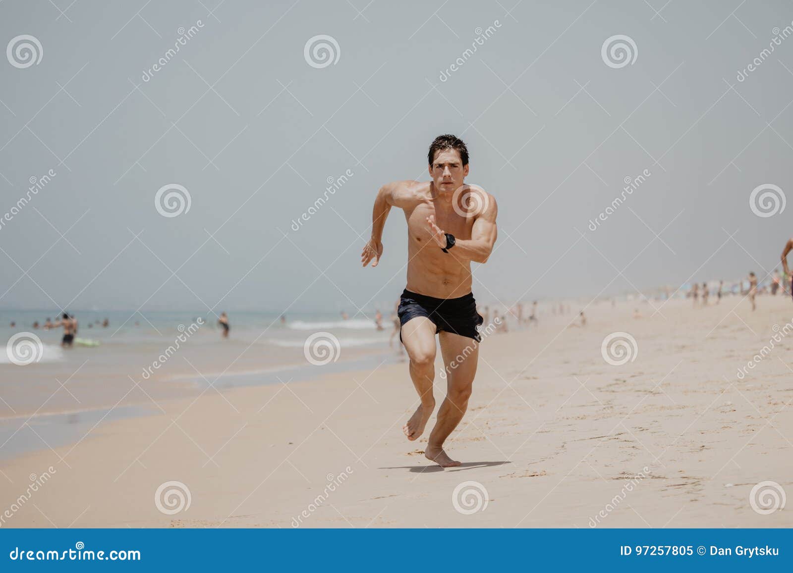 有跑沿海滩的运动员身体的年轻人