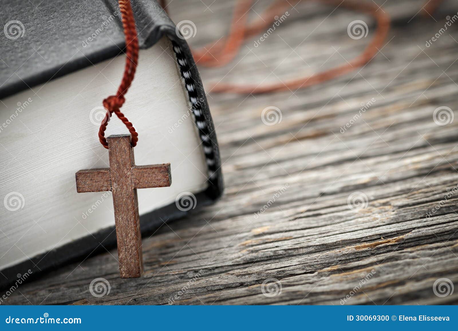 十字架和圣经. 木基督徒发怒项链特写镜头在圣经旁边的