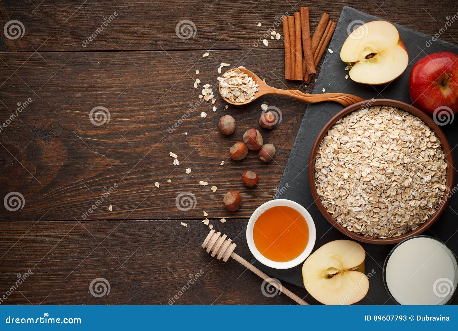 未加工的燕麦在有各种各样的成份的碗剥落在黑暗的土气木背景的早餐 顶视图，拷贝空间