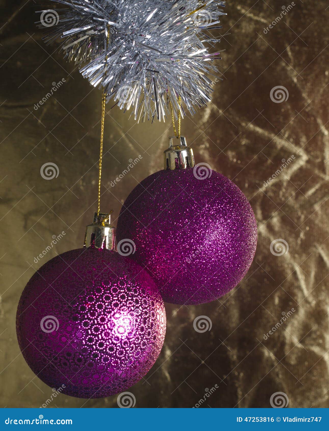 欢乐圣诞节树装饰. 在金黄不均匀的背景的两个桃红色圣诞节球