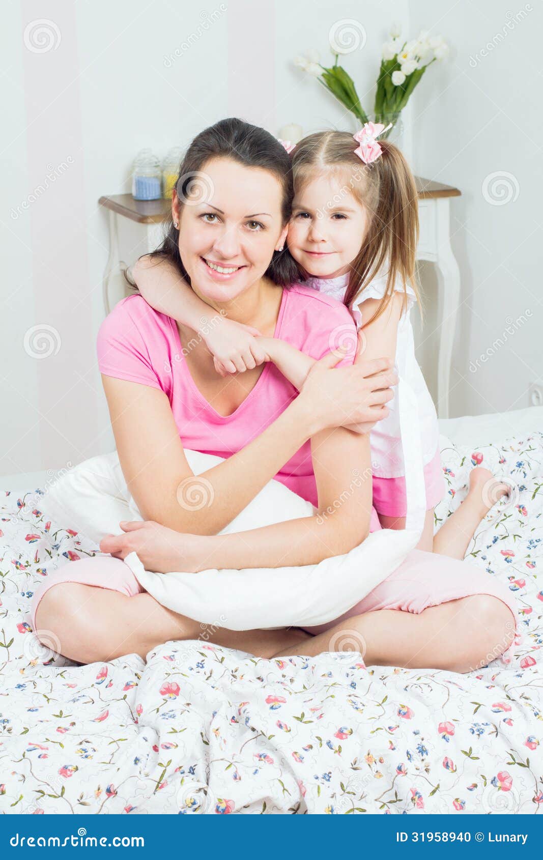 年轻妈妈坐在床上亲吻宝宝照片摄影图片_ID:418100551-Veer图库