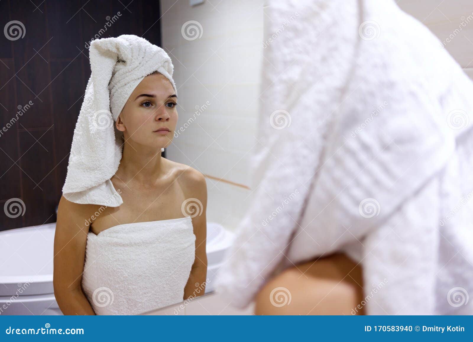 水从淋浴器里倒在女孩的手上。在蓝色背景上。一个女人在浴室后面检查水的温度照片摄影图片_ID:348802342-Veer图库
