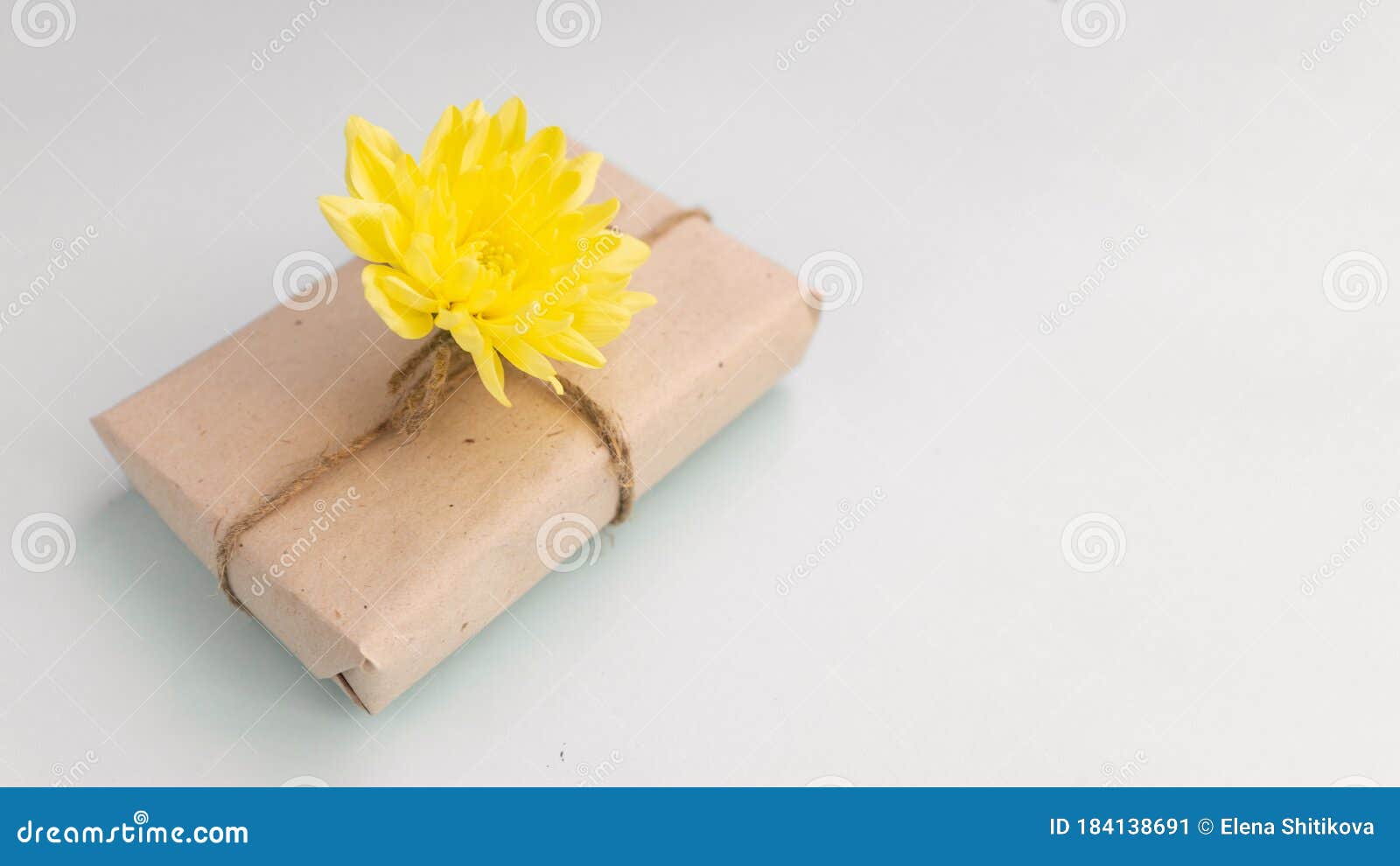 浅蓝色背景上带工艺纸和黄菊花的礼盒 为父亲的日子设定平底