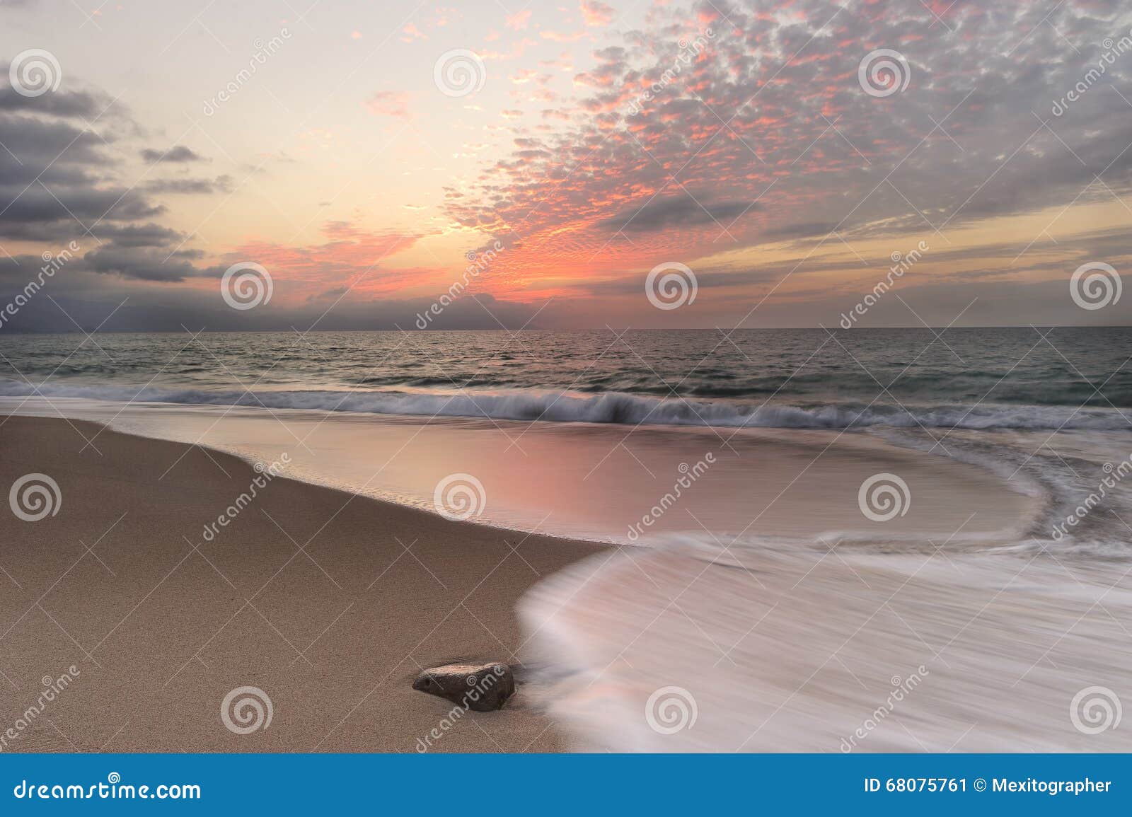 海洋日落海滩波浪. Ovean日落海滩波浪是波浪仓促的图象与发光的红色日落云彩被填装的天空的一次定时曝光夺取的在海洋天际