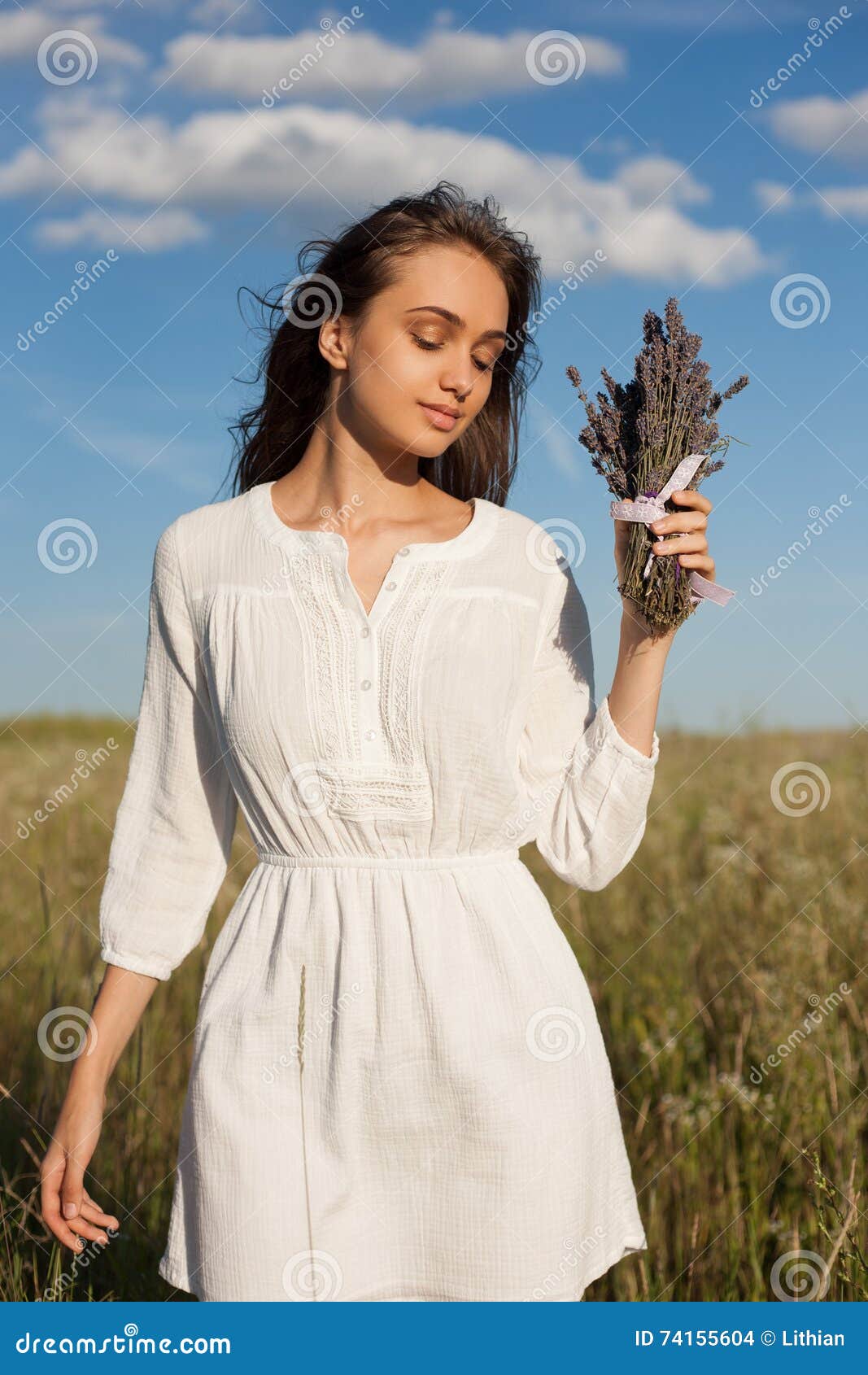 淡紫色女孩. 户外拿着淡紫色的一名华美的年轻深色的妇女的画象开花