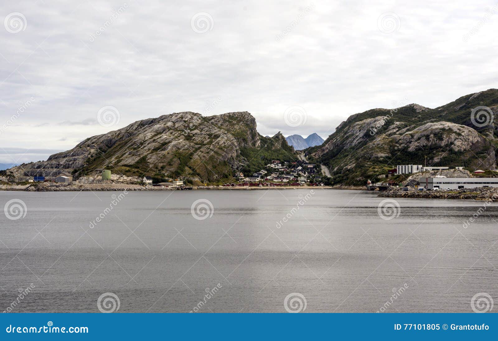 由海的挪威村庄 有山的房子在背景中在一多云天看 图象从海被采取