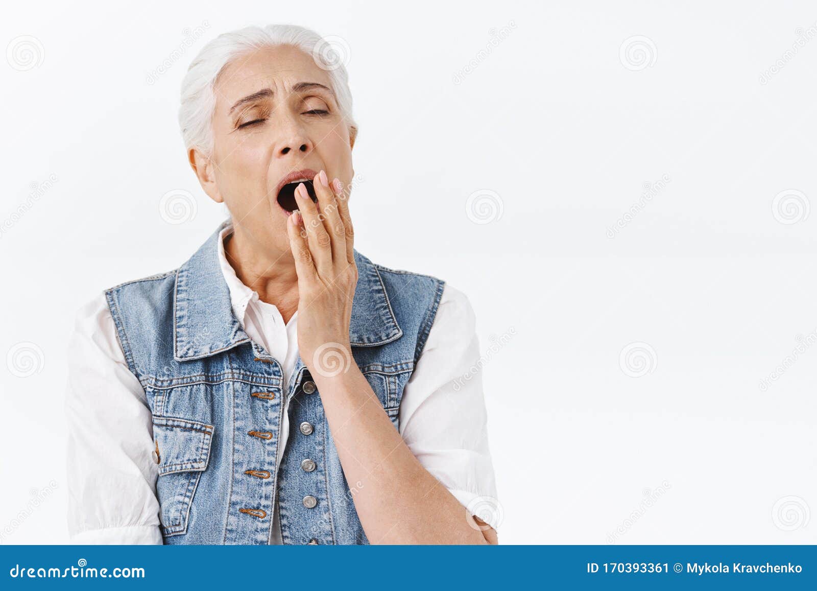疲倦的昏昏欲睡的老妇人早早醒来,打哈欠,头盖张开,手掌闭着 疲倦的昏昏欲睡的老妇人早早醒来,打哈欠,头盖张开,手掌闭着