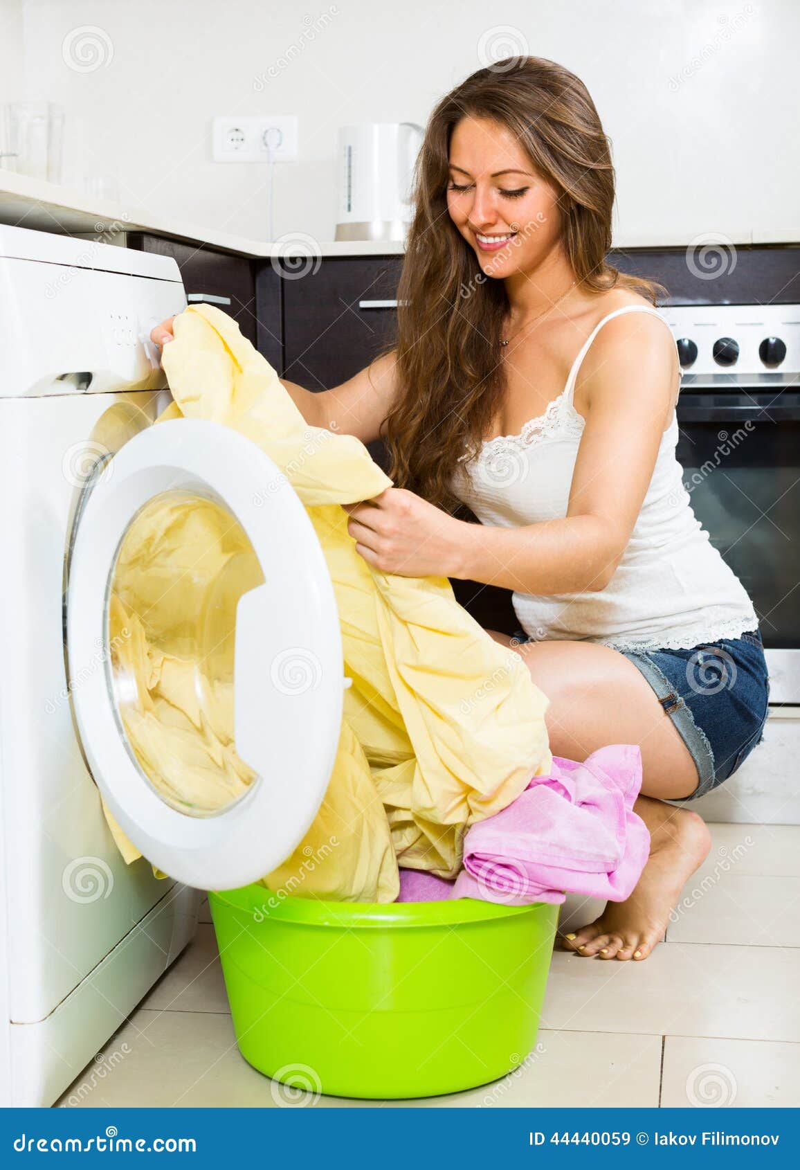 在洗衣机的微笑的少妇洗涤的衣裳 库存图片. 图片 包括有 户内, 差事, 房子, 主妇, 设备, 妇女, 女孩 - 42566813