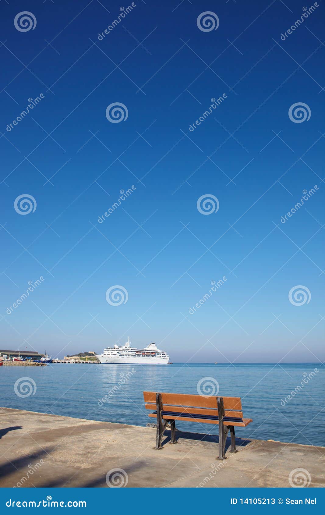 在海滨广场的小的棕色ampty长凳有在Kusadasi港，土耳其的一个空白节假日巡航划线员的，爱琴海的。