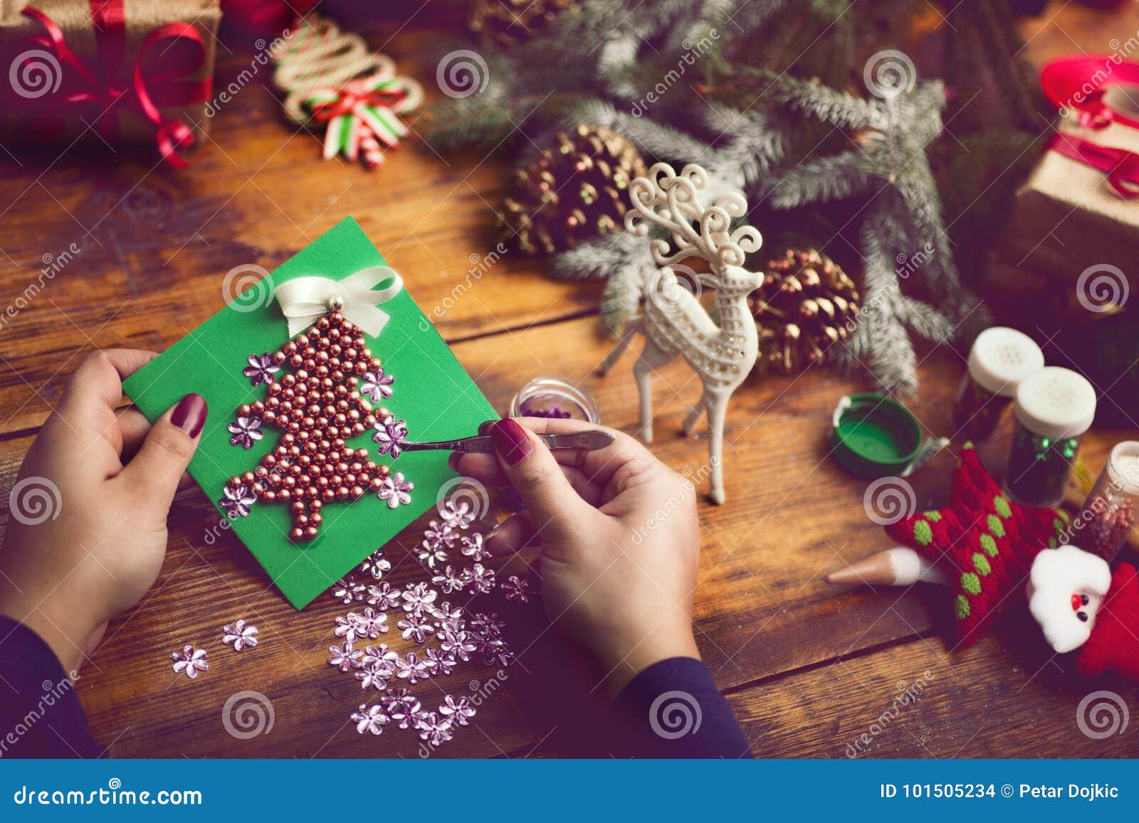 装饰圣诞节礼物和装饰的妇女的手. 手工制造新年` s或圣诞节礼物和装饰与葡萄酒作用