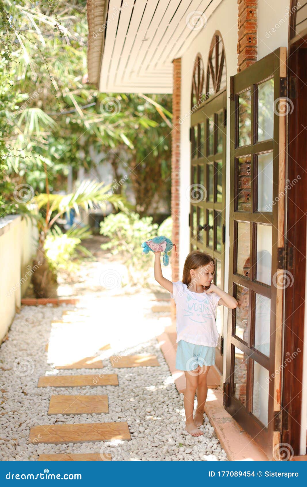 一个背着背包的小女孩赤脚走在海边的巨石上照片摄影图片_ID:351938603-Veer图库