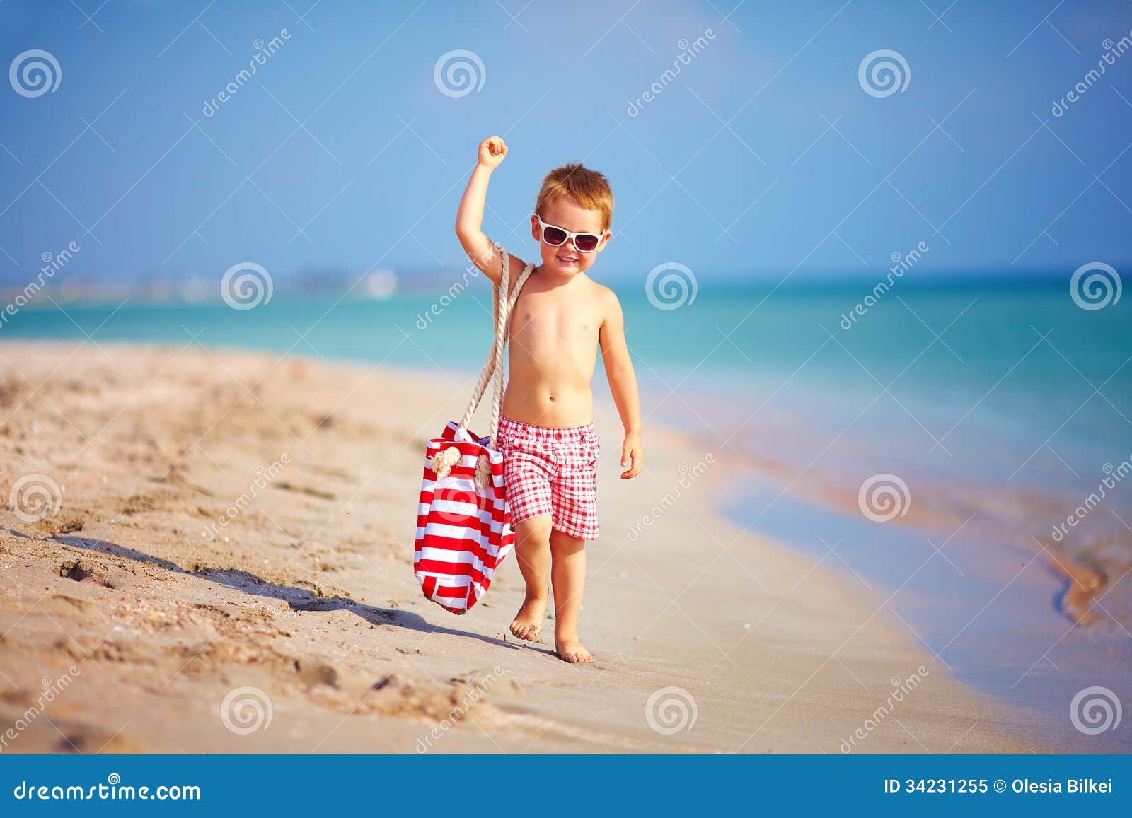 小男孩在沙滩上用铲子在沙地上挖洞照片摄影图片_ID:428638191-Veer图库