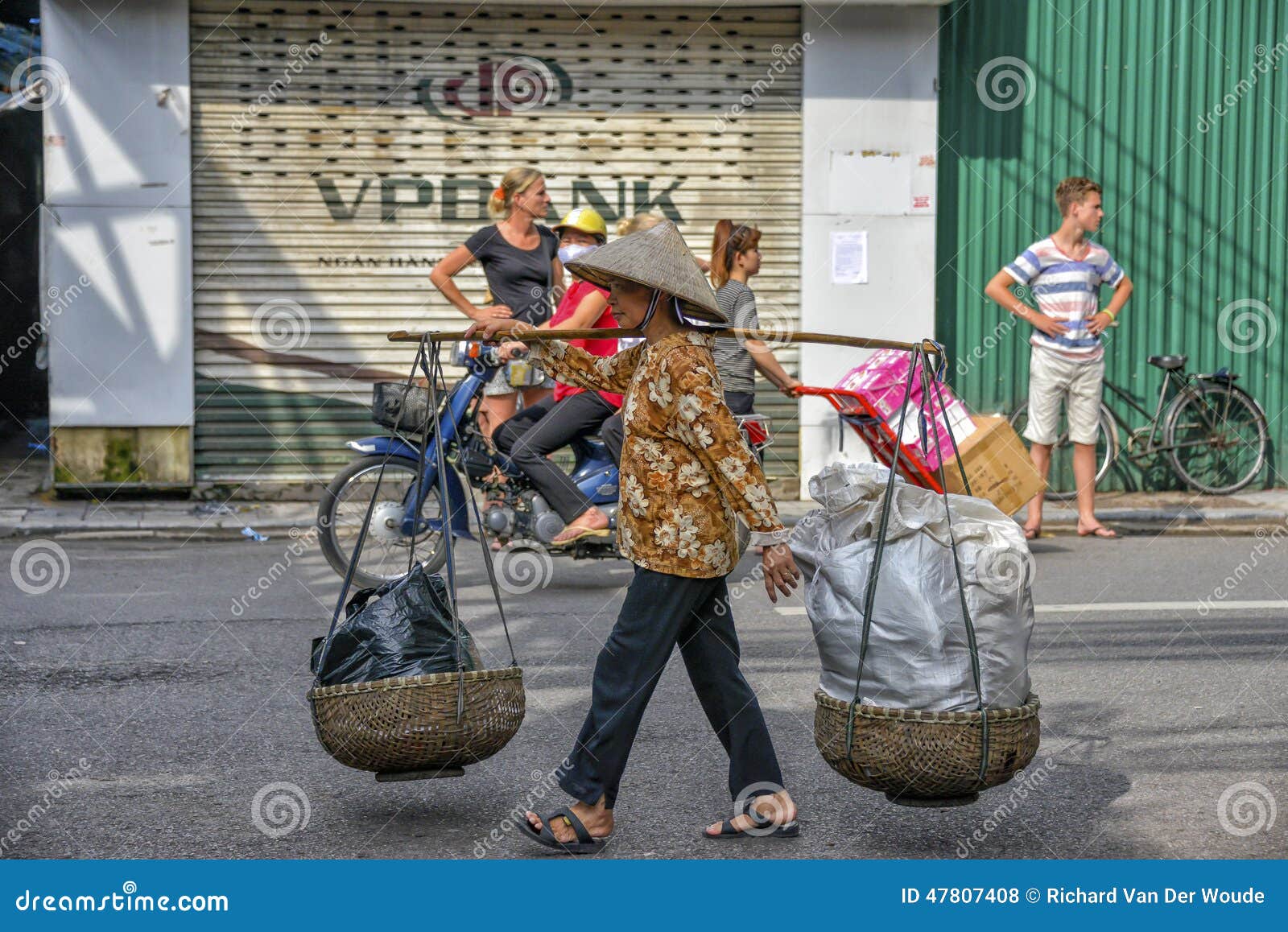 越南销售妇女在河内. 沿运载公用货物河内北部s看见街道他们对供营商非常越南