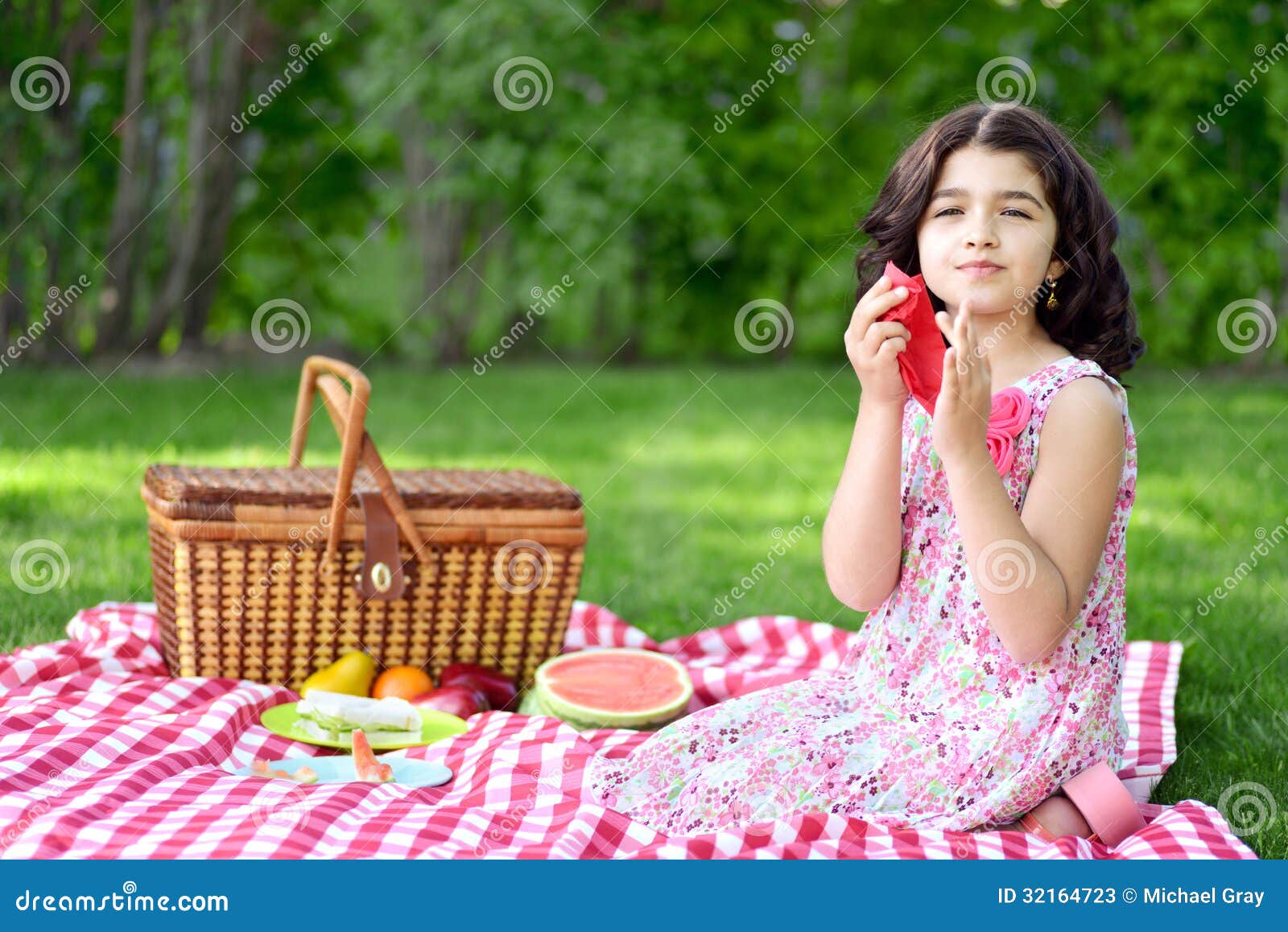 野餐的女孩使用红色餐巾在庭院里