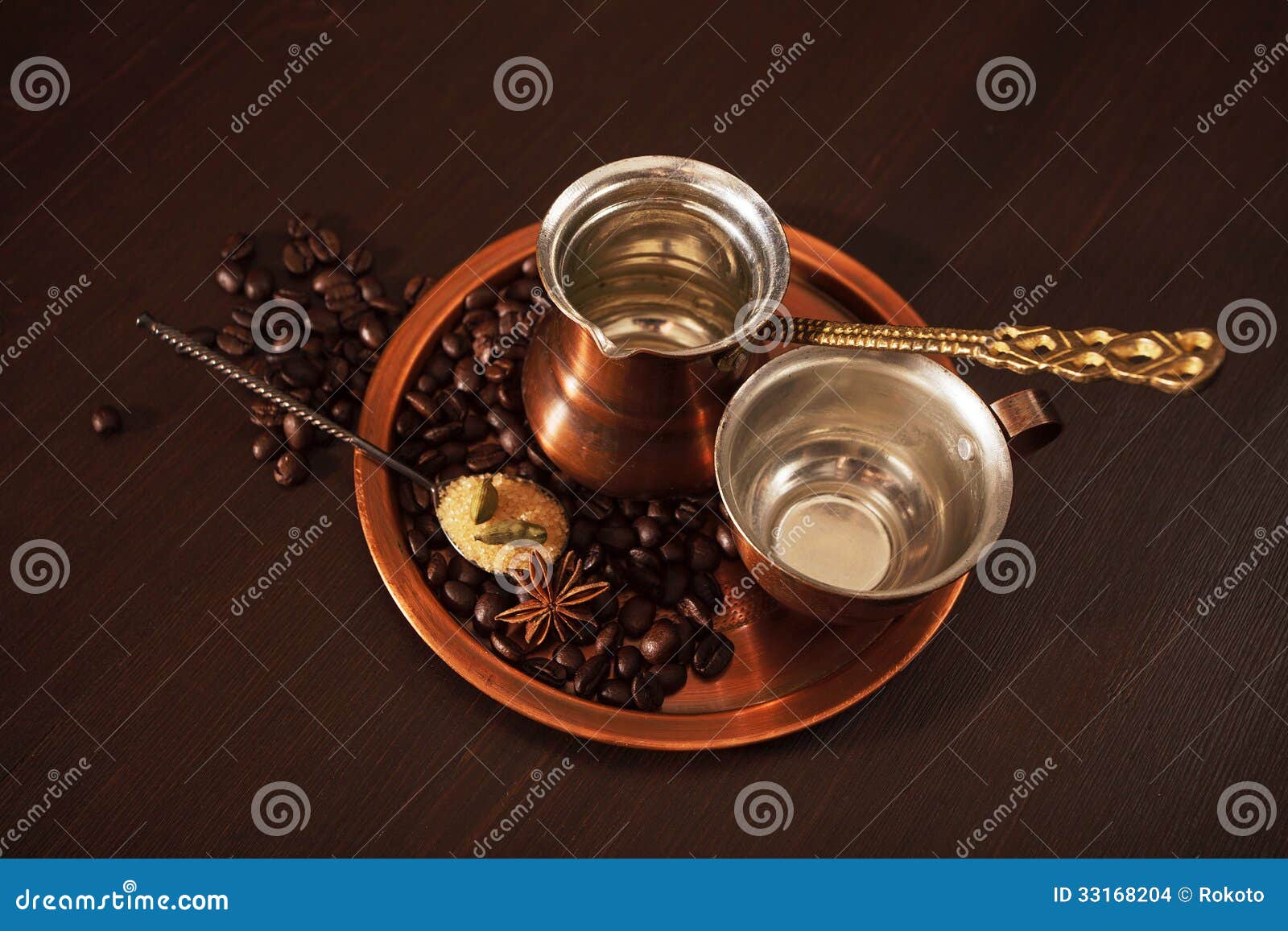 铜为做土耳其咖啡设置了用香料. 静物画、一套铜咖啡具包括板材的， cezve，是一个土耳其咖啡罐和杯子。也有咖啡豆、一个在板材的茶匙红糖和香料。黑暗的木背景。
